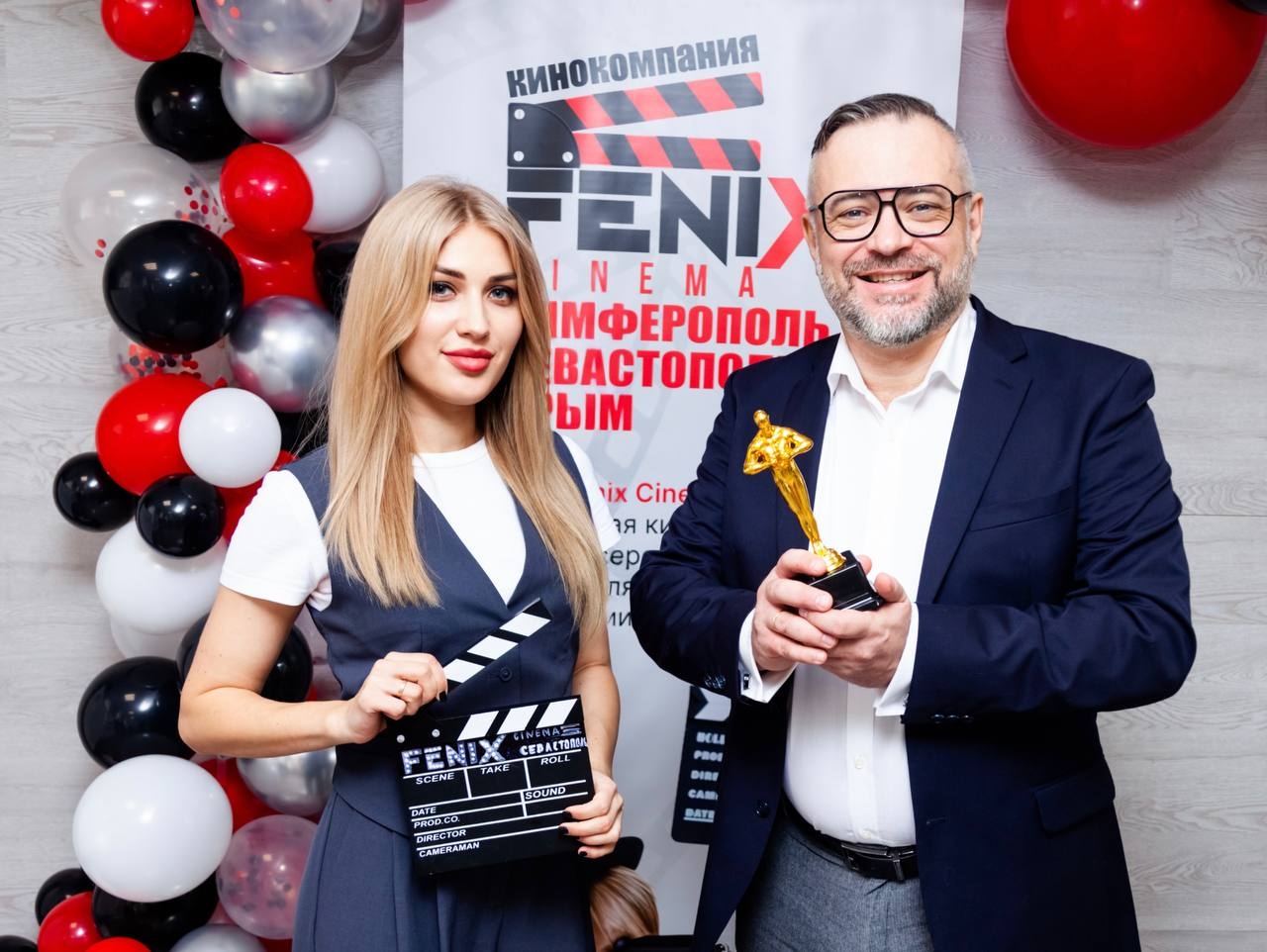 Гости у баннера Феникс Синема с хлопушкой и статуэткой