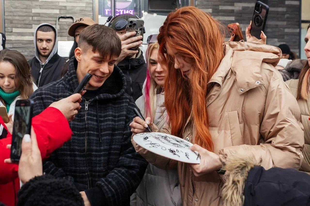 Участники встречи оставляют подписи на памятной тарелке
